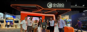 Equipo de E-dea Networks posando en su stand en el evento tecnológico ANDICOM 2026