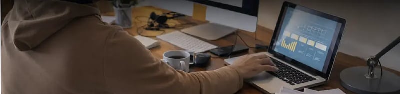 Profesional analizando métricas de monitorización de la experiencia digital (DEM) en un panel de control desde un portátil